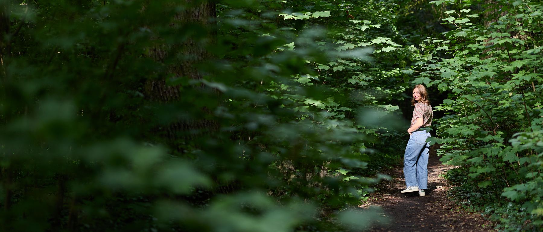 Frances Gallert geht auf einem Waldweg